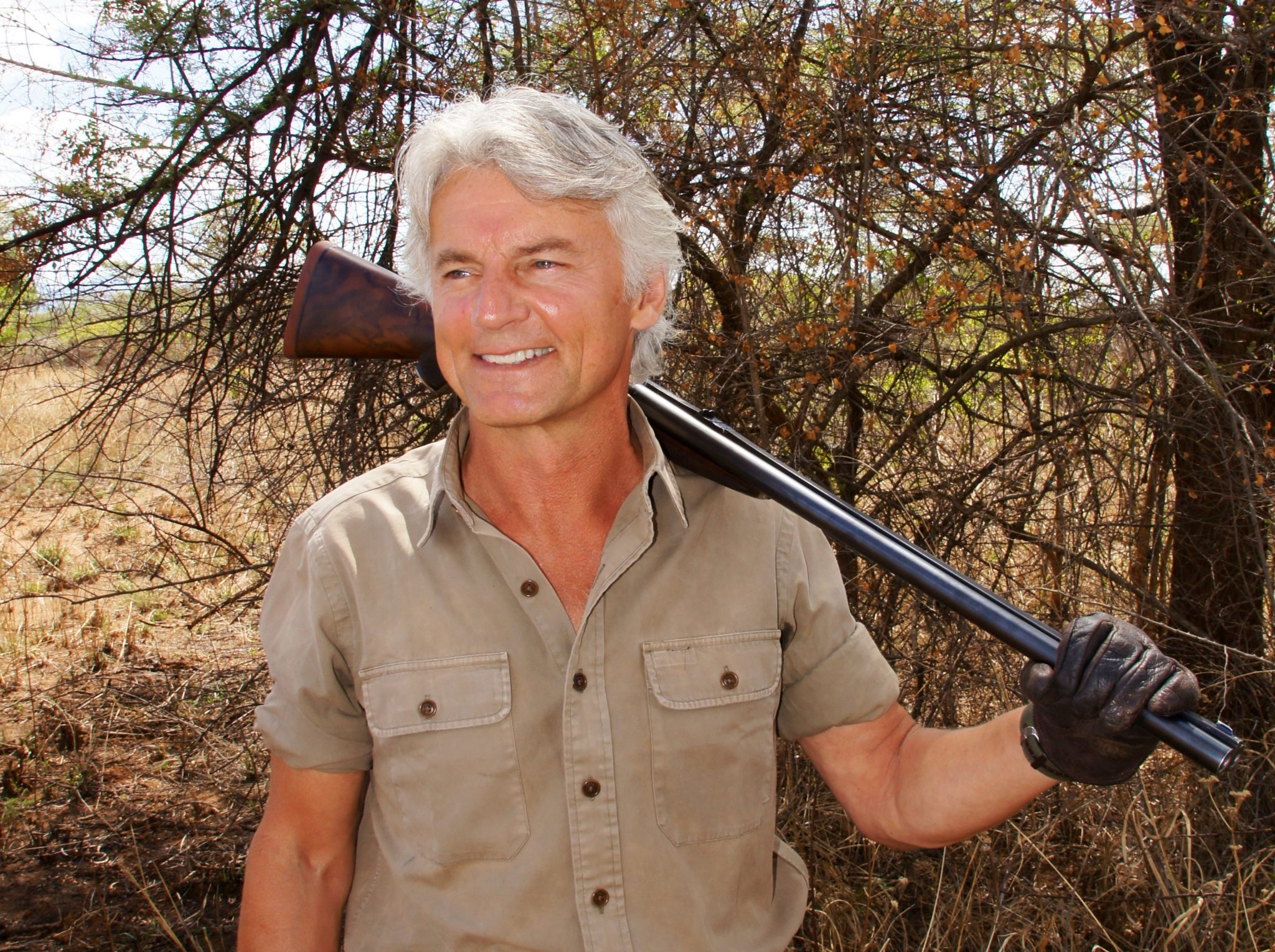 Alain2 J. Alain Smith smiling with shotgun resting on shoulder